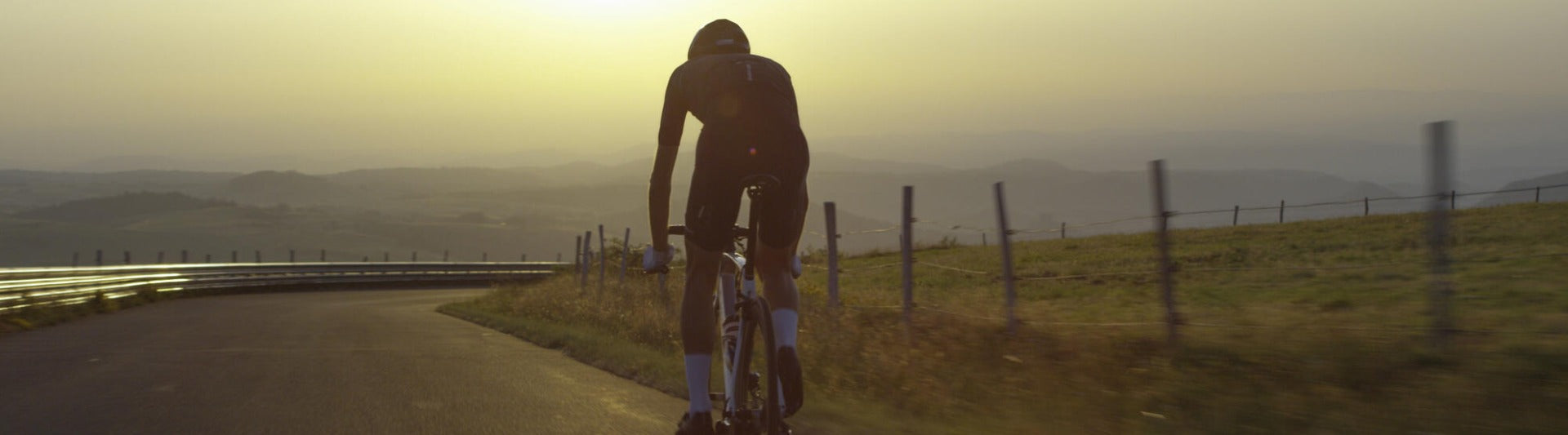 cycliste de dos roulant sur route